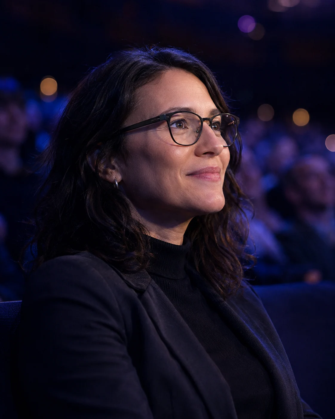 An audience member enjoying a performance while wearing a concept pair of lightweight clear-lens glasses
